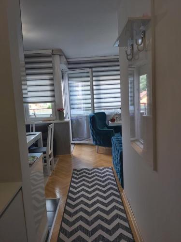 a living room with a blue couch and a table at Dora Lux & Free Indoor Parking in Vrnjačka Banja