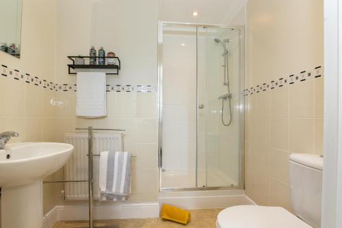 a bathroom with a shower and a toilet and a sink at 3 Bedroom Apartment, Free Parking & Fast WiFi, 65 Inch Smart TV in Milton Keynes