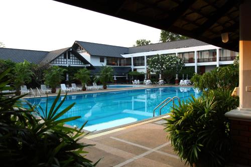 a swimming pool in front of a hotel at Korat Resort Hotel in Nakhon Ratchasima