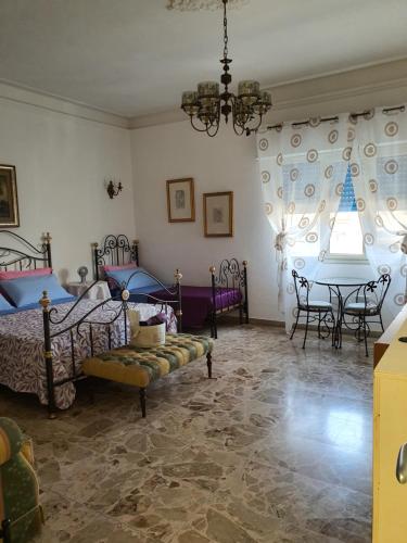 a bedroom with two beds and a table in it at Casa di Nonna Signorina in Giarre