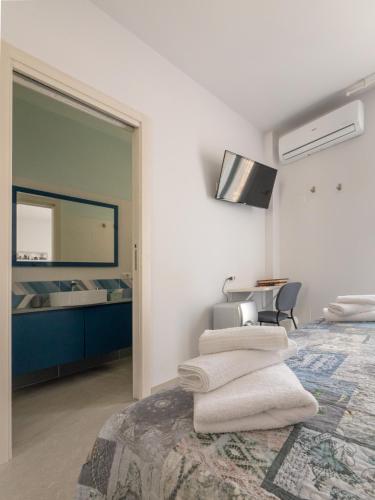 a bedroom with a bed with towels on it at Camere Casa Azzurra in Porto San Giorgio