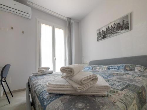 a bedroom with towels on a bed with a window at Camere Casa Azzurra in Porto San Giorgio