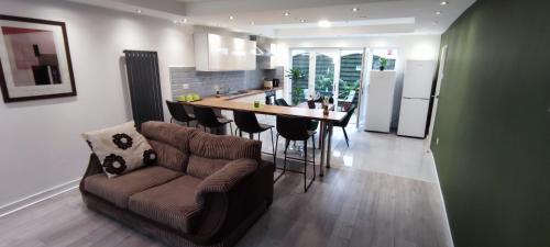 a living room and kitchen with a couch and a table at Atlas House 