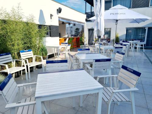 a group of white tables and chairs and umbrellas at Bunga Bunga Resort Mamaia Nord in Mamaia Nord