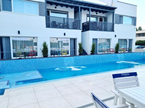 a swimming pool in front of a house at Bunga Bunga Resort Mamaia Nord in Mamaia Nord