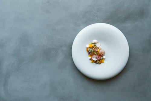 a white plate with food on top of a table at COMO Castello Del Nero in Tavarnelle in Val di Pesa