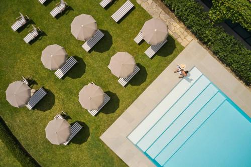 an overhead view of a pool with tables and umbrellas at COMO Castello Del Nero in Tavarnelle in Val di Pesa