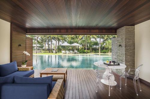 a living room with a view of a pool at COMO Uma Canggu in Canggu