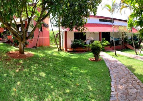 a house with a green yard with trees and a sidewalk at Hotel Rincon Rubi in Las Galeras