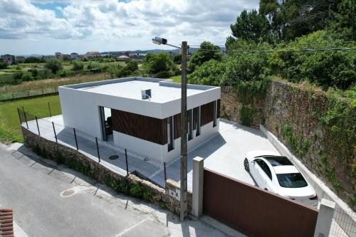 a white car parked in front of a house at Casiña de Cris in Boiro