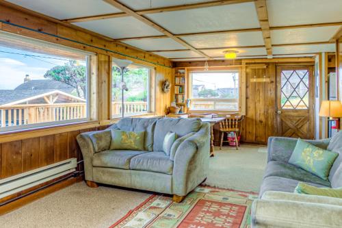 a living room with two couches and a table at Elbow's Inn in Rockaway Beach