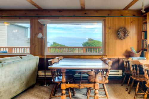 a living room with a table and a window at Elbow's Inn in Rockaway Beach