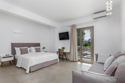 Habitación blanca con cama y sofá en Stavros Beach Hotel en Stavros