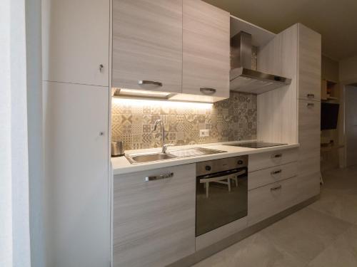 a kitchen with white cabinets and a sink at Appartamento Casa Azzurra in Porto San Giorgio