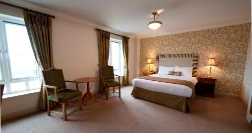 una camera d'albergo con letto, tavolo e sedie di Bracken Court Hotel a Balbriggan