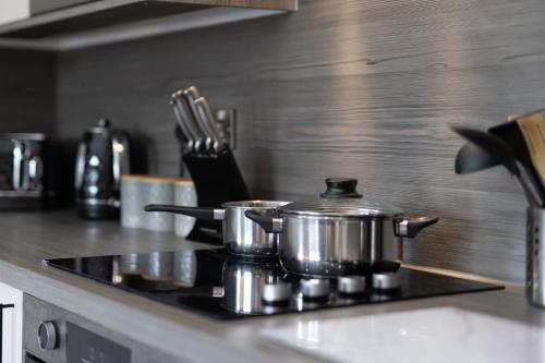 two pots on a stove top in a kitchen at Cedar Cottage in Tenby