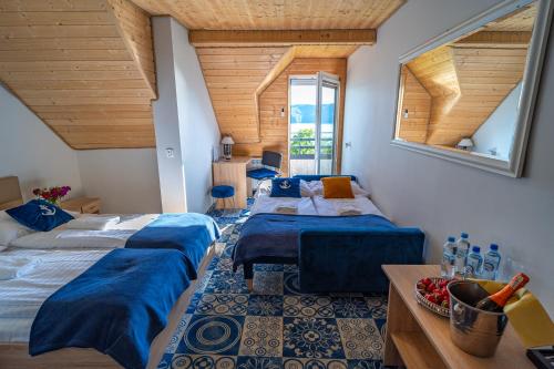 2 łóżka w pokoju z drewnianym sufitem w obiekcie Willa Admirał Solina w Solinie