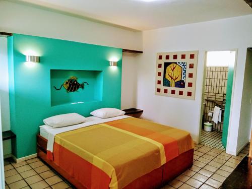 a bedroom with a bed with a colorful wall at Pousada Marahú in Porto De Galinhas