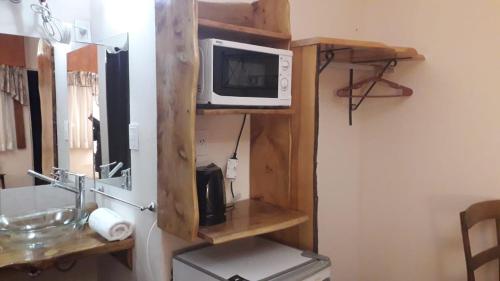 een magnetron op een plank naast een wastafel bij Teilen in Villa General Belgrano