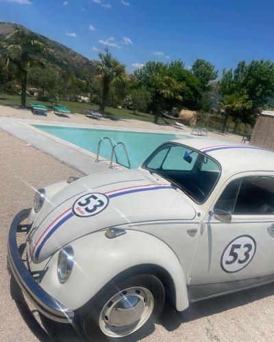 an old car parked next to a swimming pool at Agriturismo Il Pozzo in Polla