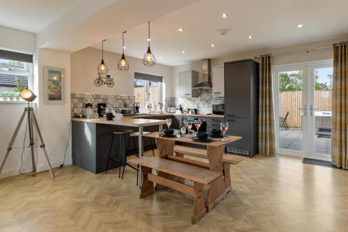 a kitchen with a bench and a table in it at Hazel Cottage in Tenby