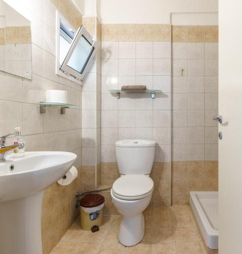 a bathroom with a toilet and a sink at Apartments Alexandros in Polykhrono