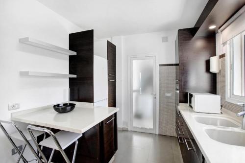 a white kitchen with a counter and a sink at Villa Sol in Adeje