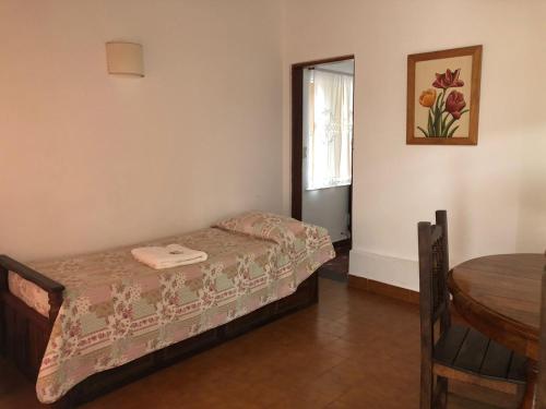 een kleine slaapkamer met een klein bed en een tafel bij Teilen in Villa General Belgrano