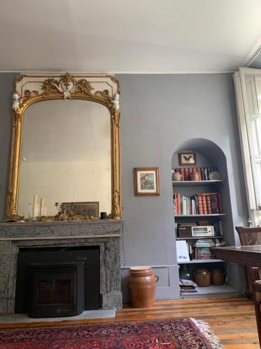 a living room with a mirror over a fireplace at La Maison in Saint-Béat