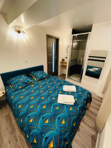 - une chambre avec un lit doté d'une couette bleue et jaune dans l'établissement Superbe T2 tout équipé à la gare de Lorient, à Lorient