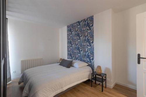 una camera da letto con un letto con una parete con accento blu di CABANA & Mâcon Rive Gauche a Mâcon