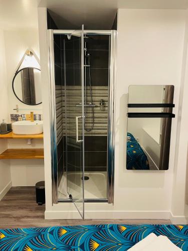 une douche en verre dans une salle de bain avec un lavabo dans l'établissement Superbe T2 tout équipé à la gare de Lorient, à Lorient