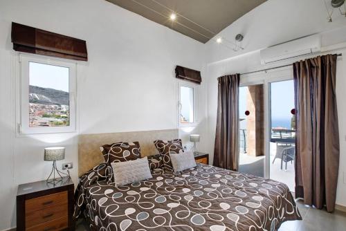 een slaapkamer met een bed en uitzicht op de oceaan bij Villa Sol in Adeje