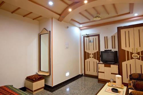 a room with a bed and a tv and a mirror at Hotel Kalyan in Jaipur