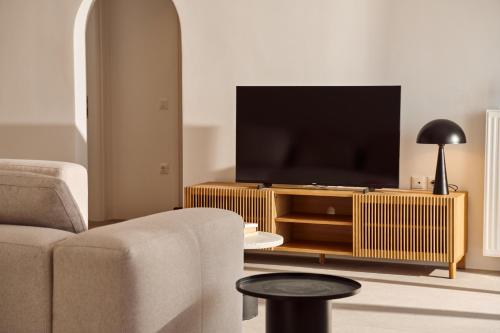 a living room with a couch and a television at Lilium Homes in Karterados