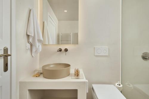 a white bathroom with a sink and a shower at Lilium Homes in Karterados
