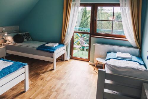 a small room with two beds and a window at Dom Uzdrowisko in Tolkmicko