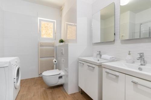 a white bathroom with a toilet and a sink at Jadranka in Rabac