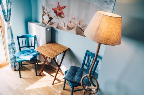 a room with two chairs and a table and a lamp at Dom Uzdrowisko in Tolkmicko