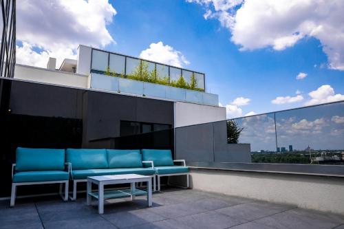 a balcony with blue chairs and a table on a building at Novum Aparthotel in Bucharest