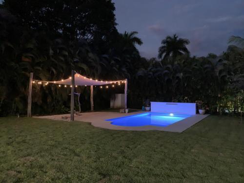 a pool in a yard with a tent and lights at Villa Serenidad in Paquera