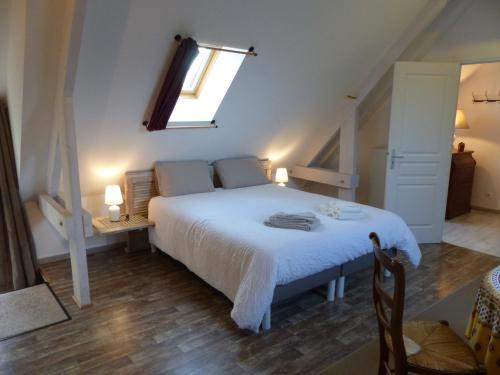 Schlafzimmer mit einem großen weißen Bett und einem Fenster in der Unterkunft Cottage des Mézières in Saint-Germain-sur-Ay