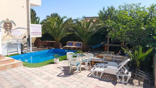 un patio con mesa, sillas y piscina en Villa Dobra Family Apartments en Vir