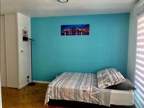 una camera da letto con una parete blu e un letto di Superbe studio lumineux haut de gamme tout confort a Drancy