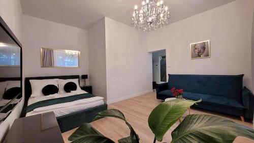 a bedroom with a bed and a couch and a chandelier at Good Day Apartment 2 centrum Katowice in Katowice