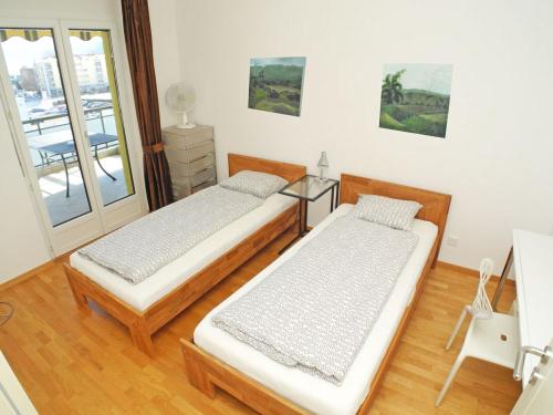 dwa łóżka w pokoju z oknem w obiekcie Casa Robinia App 4000 w mieście Locarno