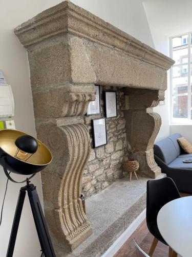 - une grande cheminée en pierre dans le salon dans l'établissement Pavillon  T2  Pontivy Gare, à Pontivy