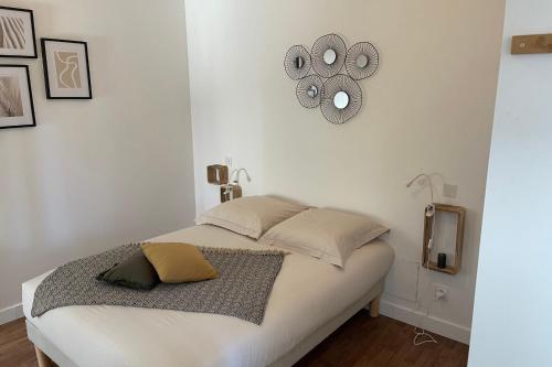 - une chambre dotée d'un lit avec une horloge murale dans l'établissement Pavillon  T2  Pontivy Gare, à Pontivy