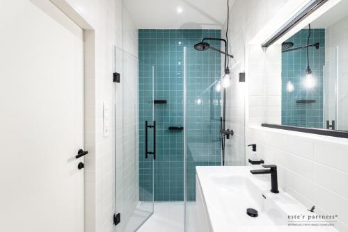 W łazience znajduje się szklana kabina prysznicowa i umywalka. w obiekcie White Boat Apartment BLUE w Budapeszcie