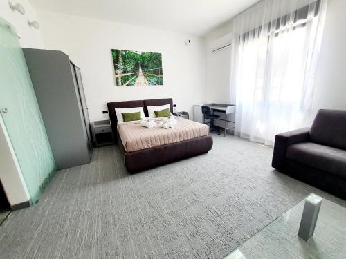 - une chambre avec un lit et un canapé dans l'établissement Camere Fiera Verona - CasaNostra, à Vérone
